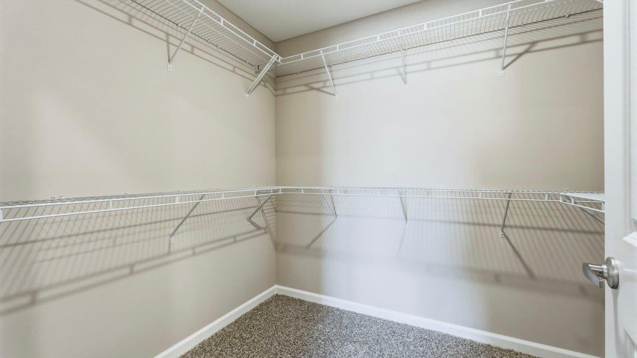 ensuite primary walk-in closet with shelving built-in