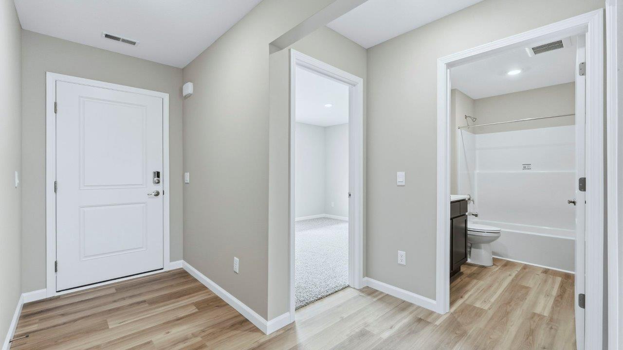 foyer with mohawk avery lvp flooring leading to bedrooms, bathrooms, and open floorplan living spaces