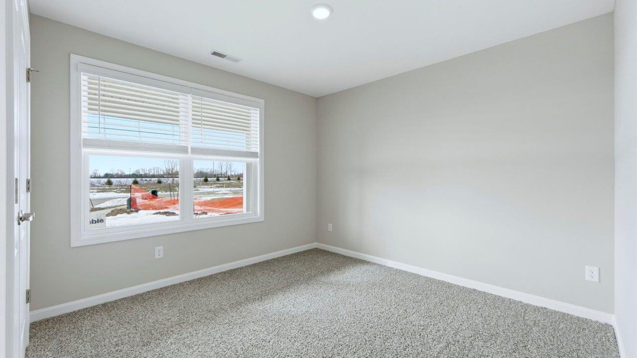 bedroom 2 front of home with carpet flooring, 2 windows, and closet