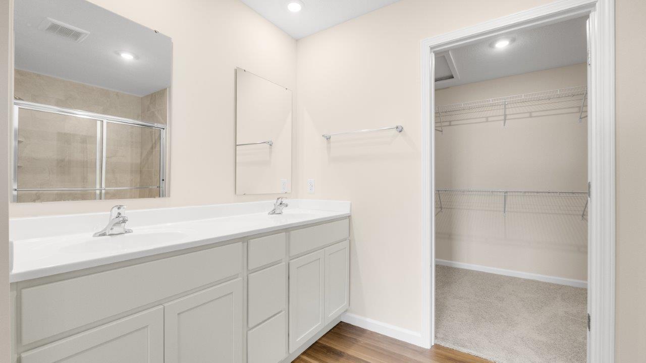 wabash primary bathroom with dual sinks and additional walk in closet