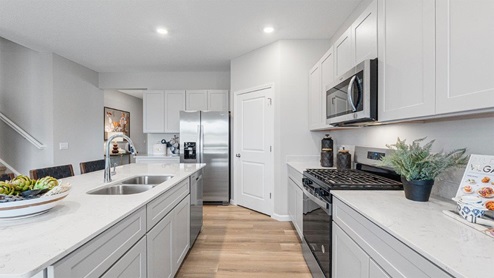 belmont woods henley kitchen with lvp, large island, stainless steel, and large pantry