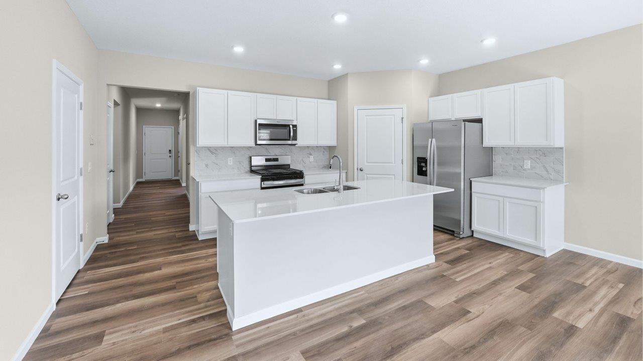 foyer leading into open floorplan with kitchen, living room, and dining room