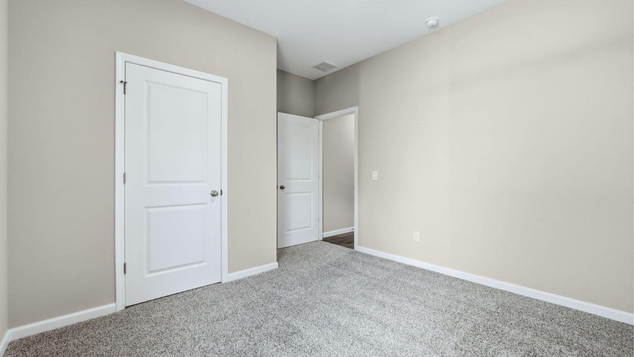 bedroom 2 with carpet flooring, popular grey walls, and ensuite closet