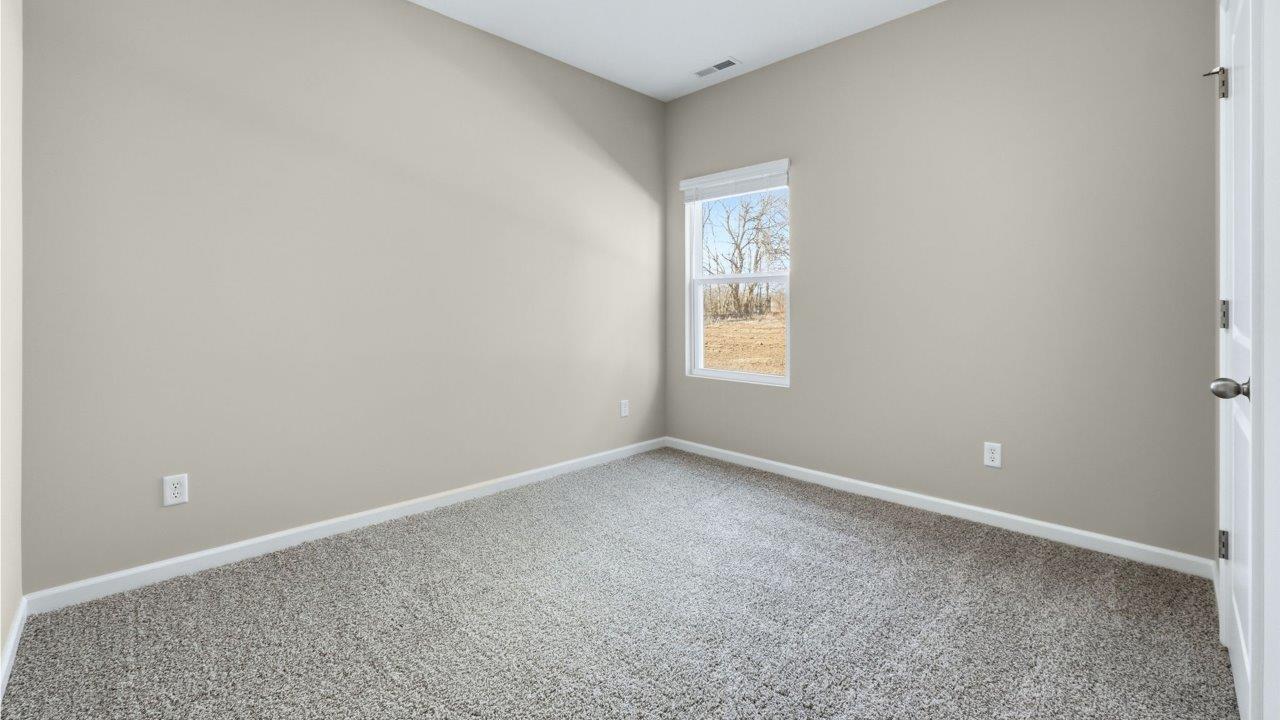bedroom 2 with carpet flooring, popular grey walls, and ensuite closet