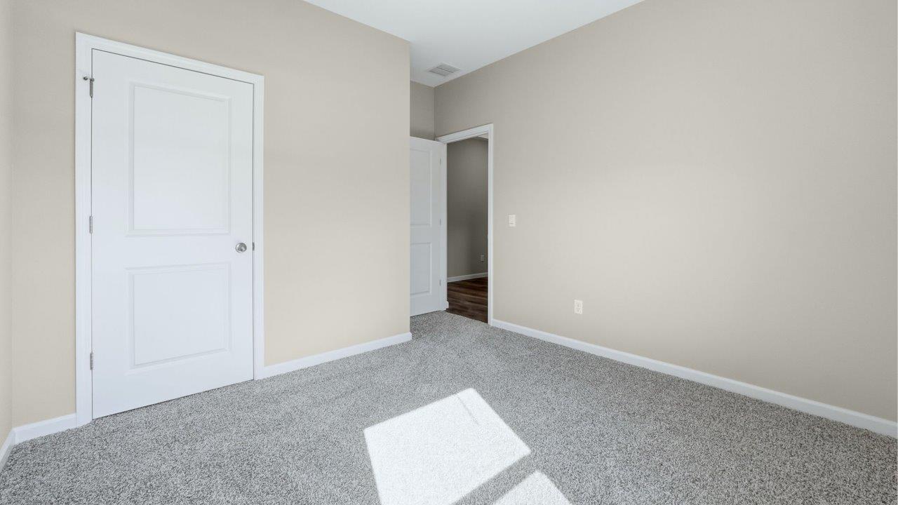 bedroom 3 with carpet flooring, popular grey walls, and ensuite closet