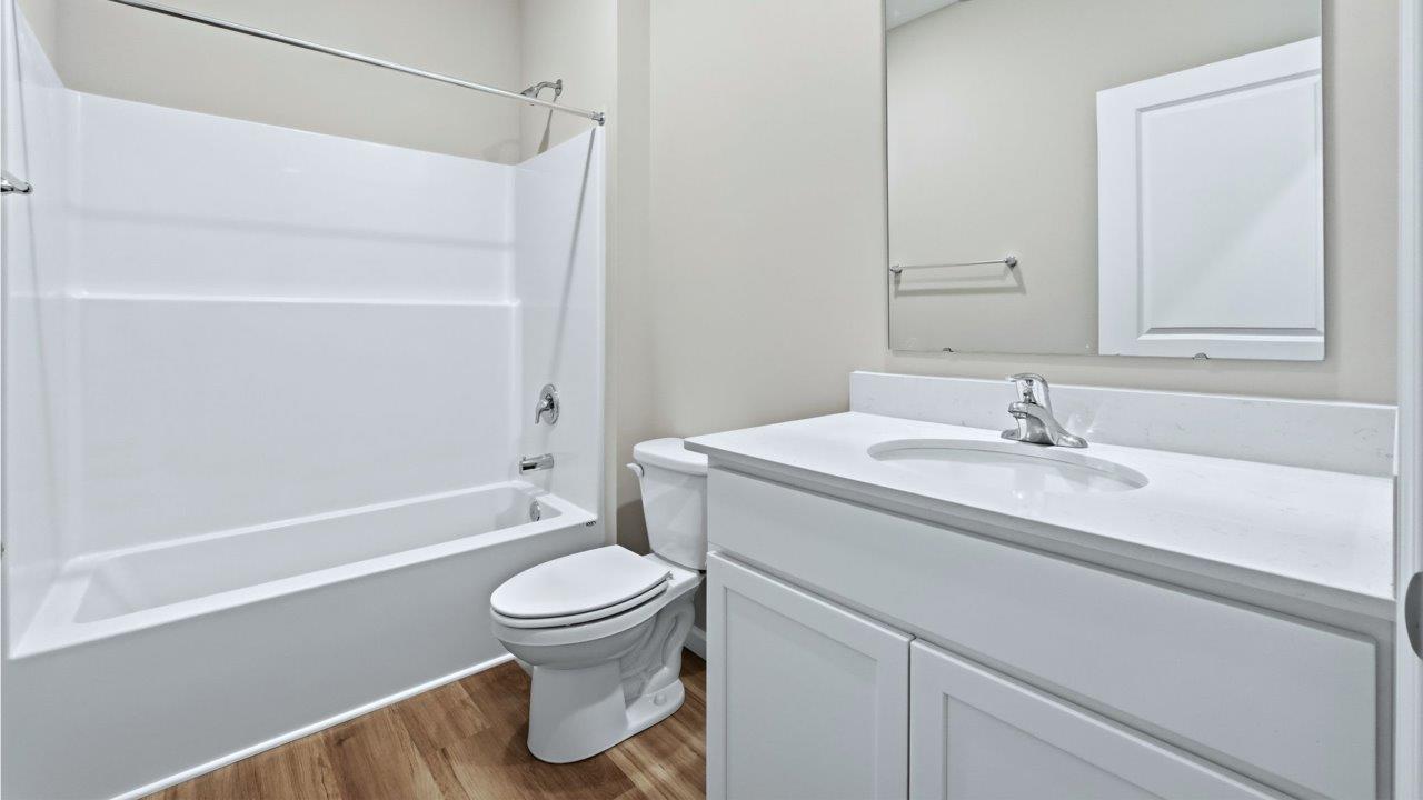 full bath with single sink vanity and tub shower