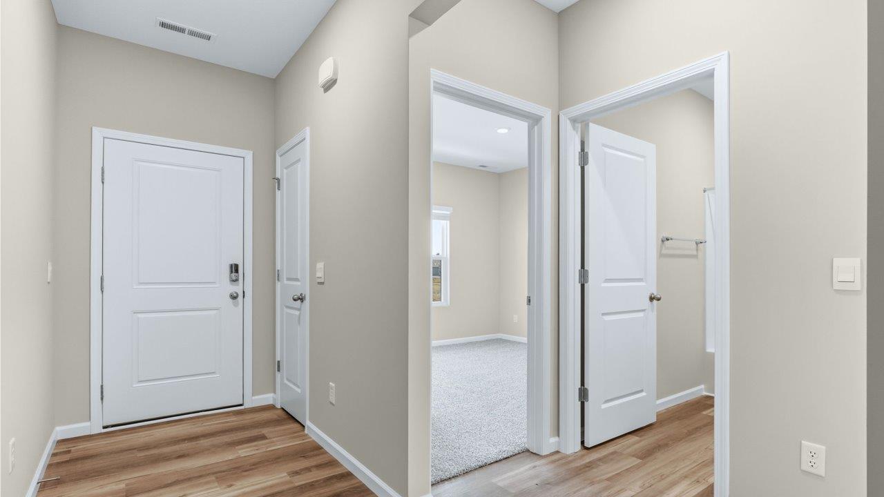 foyer with lvp flooring and popular grey walls