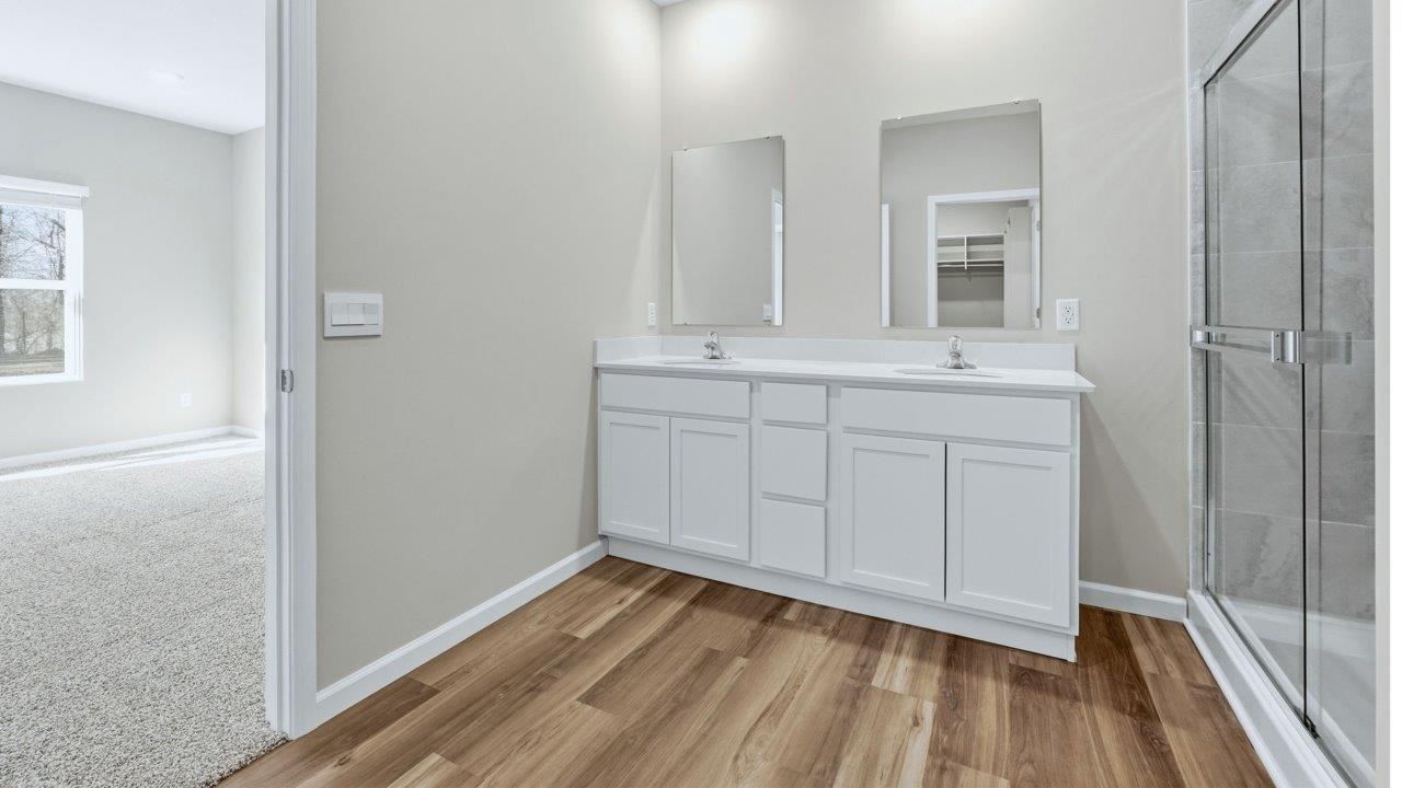 primary ensuite bathroom with dual vanity sinks/shower