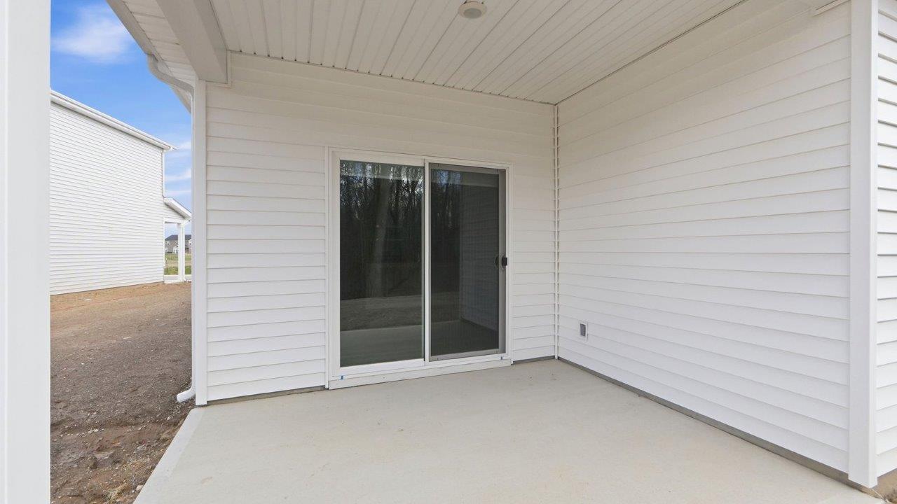 rear exterior with covered porch and tree lined yard