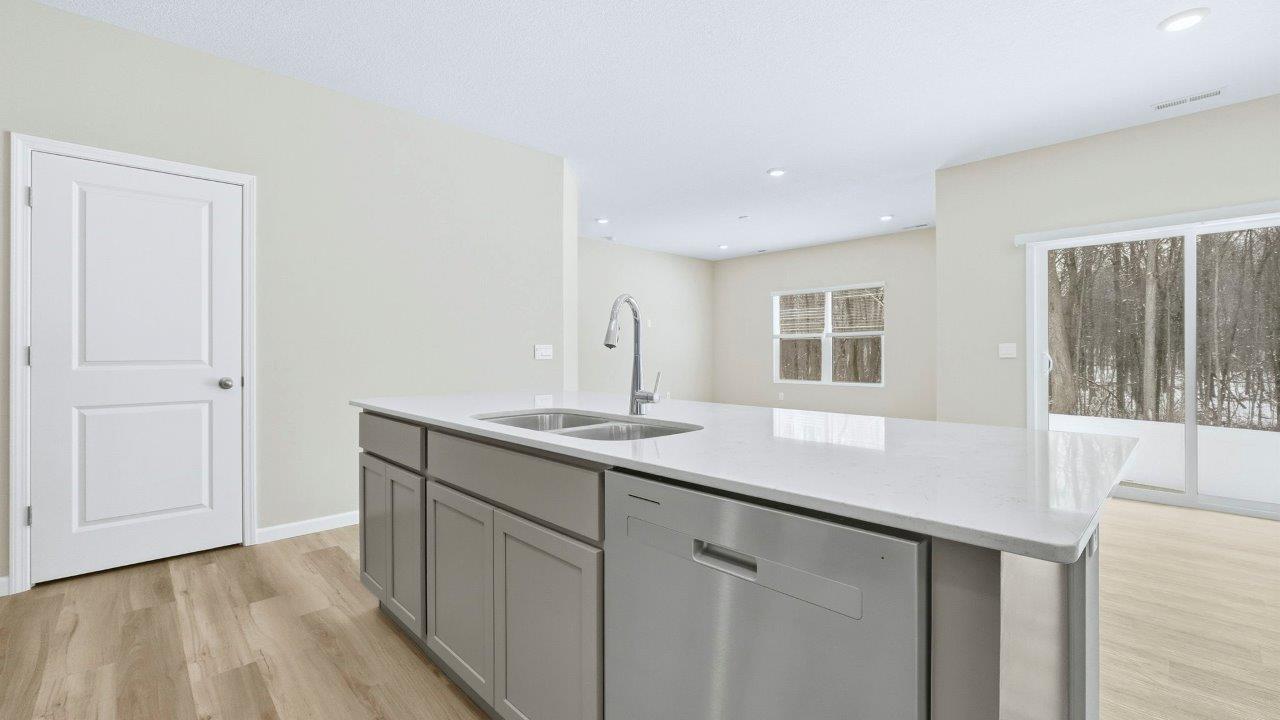 kitchen center island with built-in sink and dishwasher with bar seating.