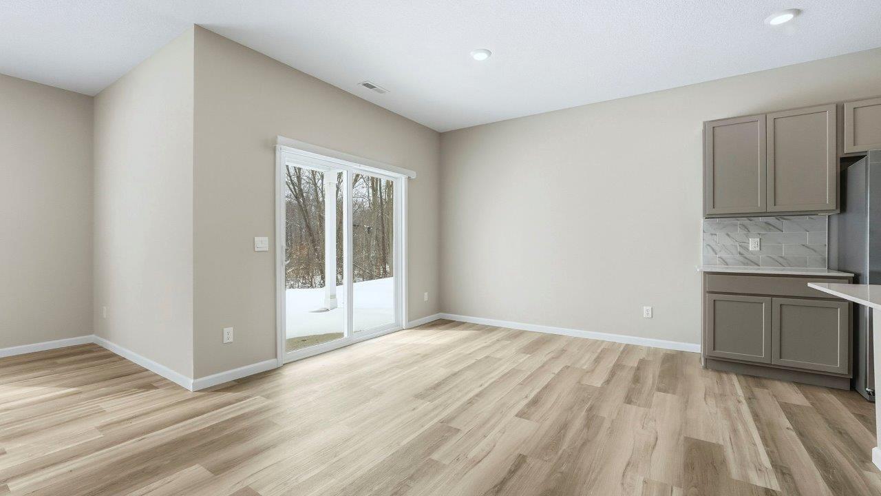 casual dining room with lvp flooring and sliding door to backyard patio