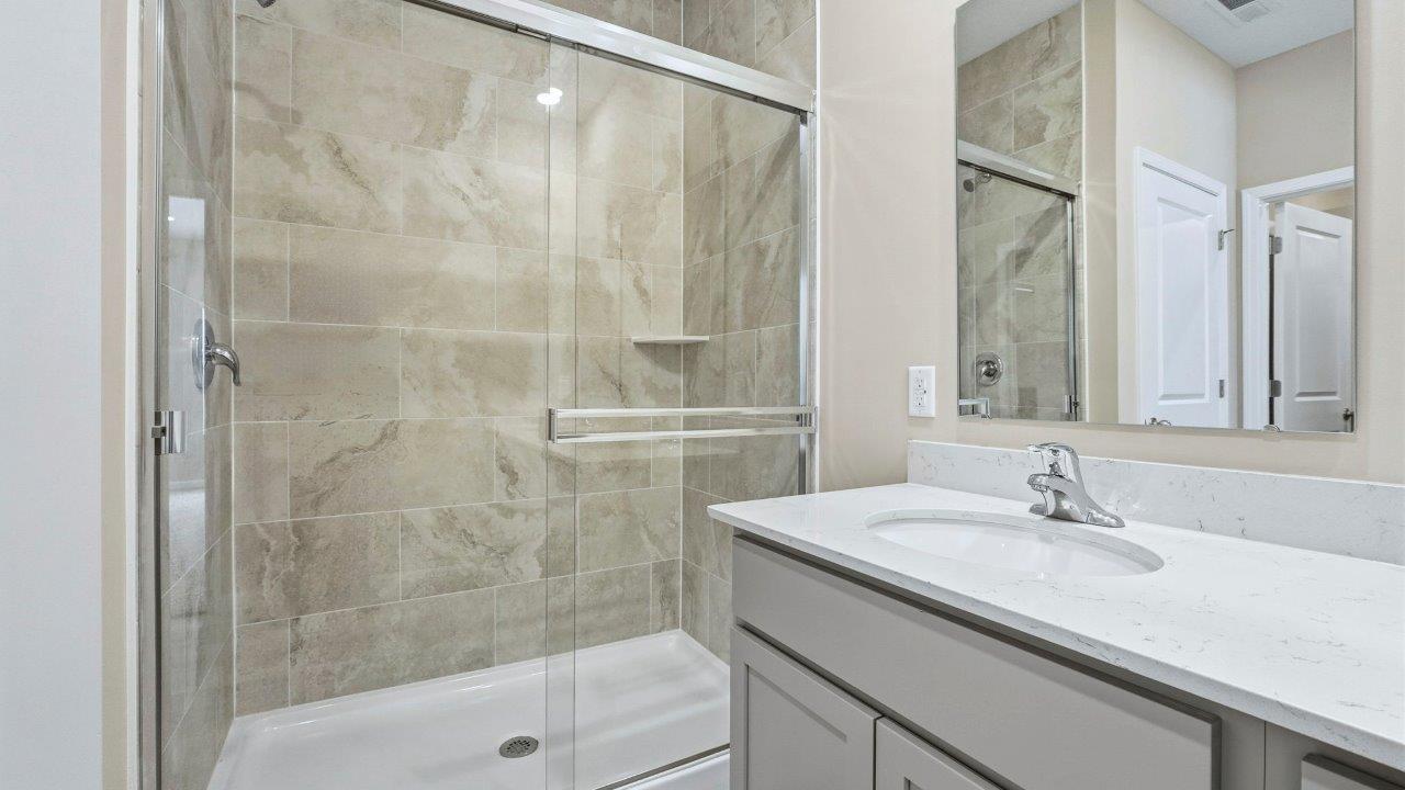 primary ensuite bathroom with dual sinks, lvp flooring, private water room, and ceramic tile shower