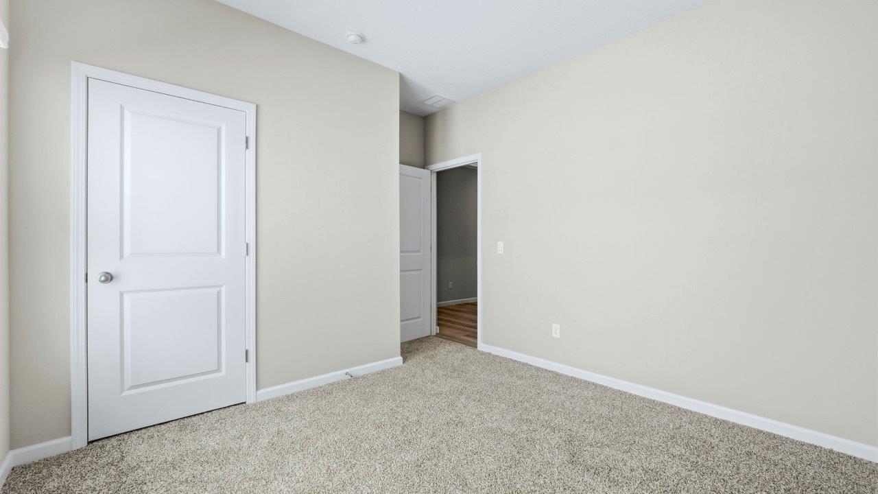 bedroom 2 with carpet, closet, and two windows