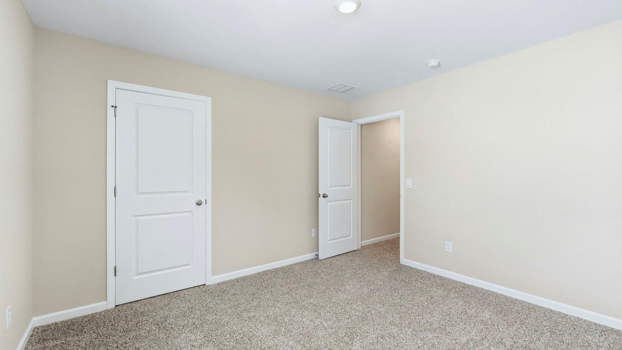 bedroom 2 with elk beige carpets, single window, and closetdroom 2