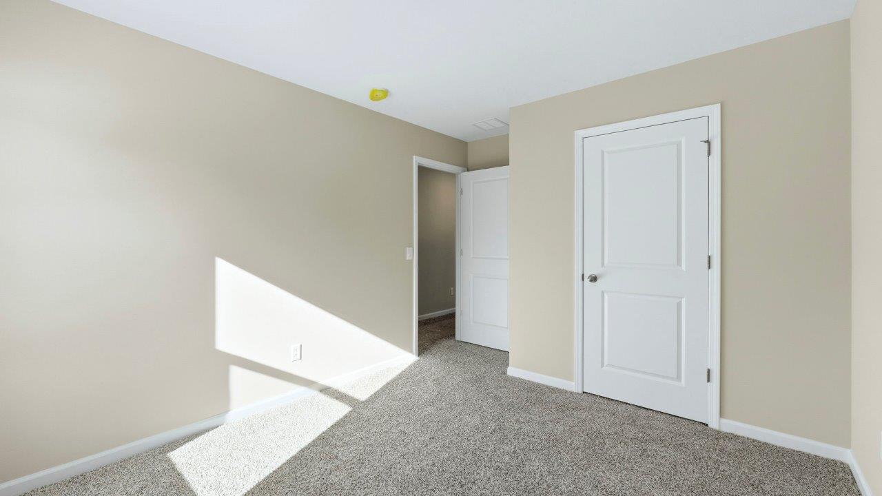 bedroom 3 with elk beige carpets, single window, and closet