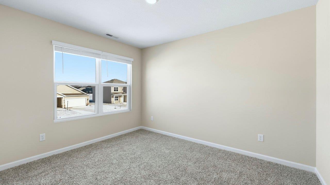 bedroom 4 with elk beige carpet, 2 windows, and a closet
