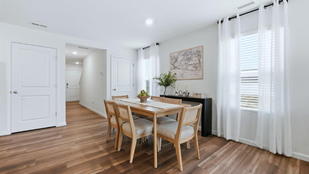 thunderhawk model home elm plan casual dining room with mohawk lvp flooring and plenty of natural lighting near kitchen and living room