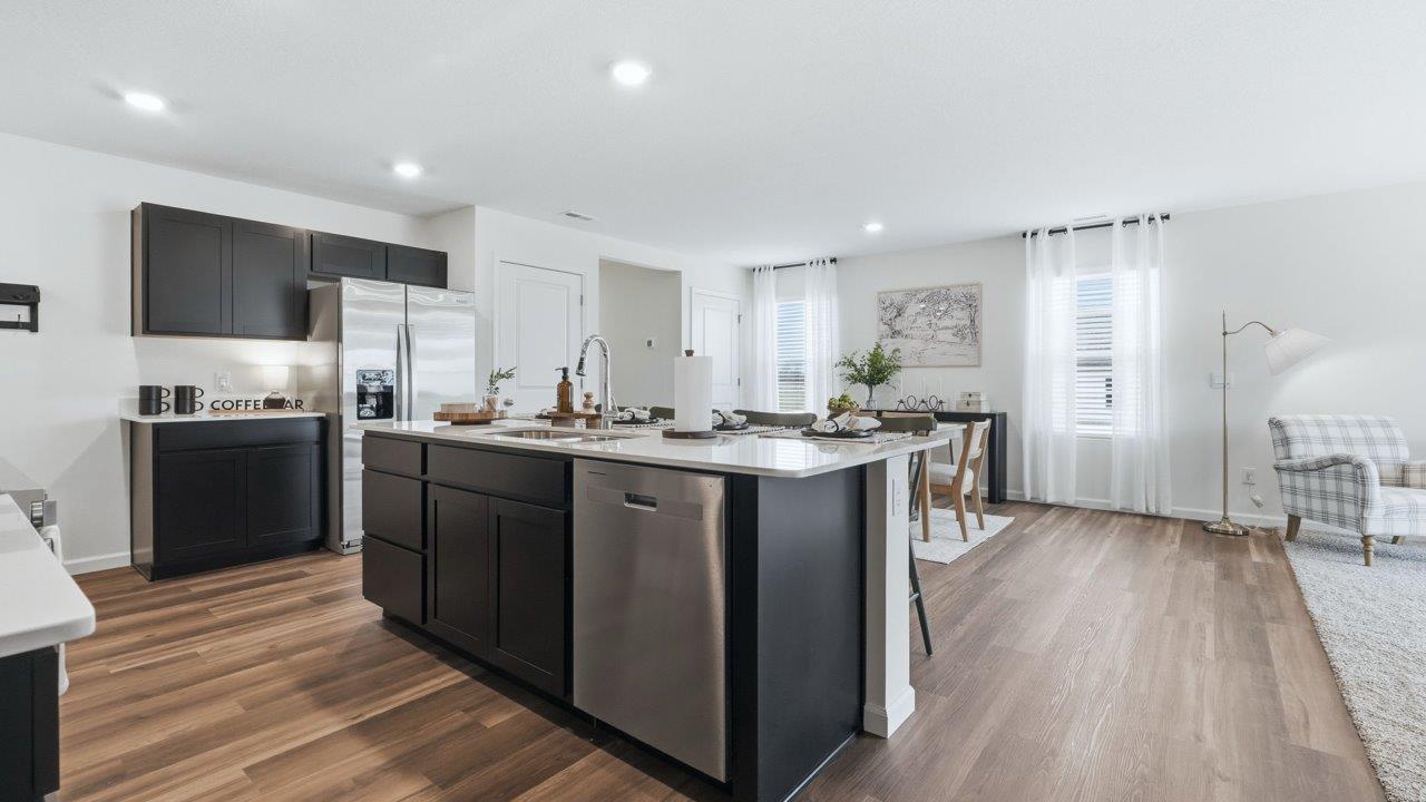 thunderhawk elm model home kitchen with sarsaparilla cabinets, quartz countertops, pantry, and spacious center island with bar seating