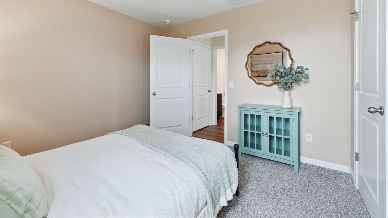 thunderhawk elm model home first floor guest bedroom 5 with carpet and pink walls near full bathroom
