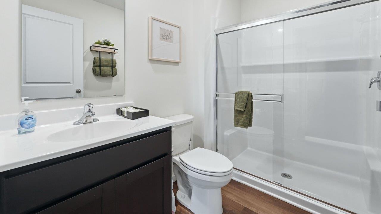 thunderhawk elm model home first floor full bathroom with single vanity sink and walk in shower with mohawk lvp flooring