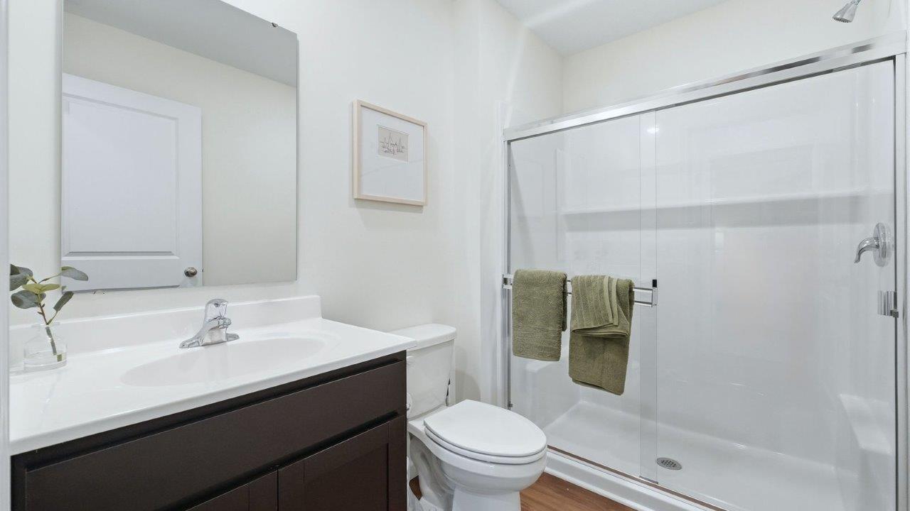 thunderhawk model home elm plan first floor full bathroom with single sink vanity with sarsaparilla cabinets and fiberglass walk in shower