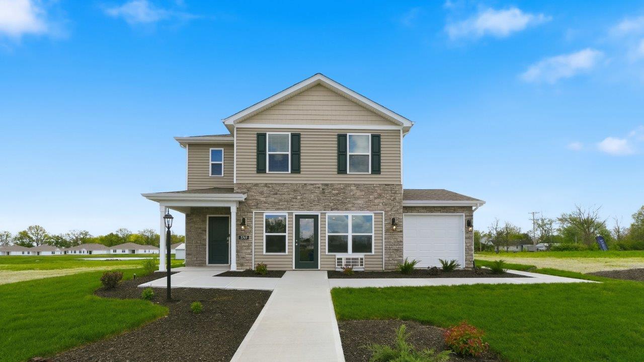 Thunderhawk elm model home exterior with ridgeline stone, sod, landscaping, and a 3 car garage