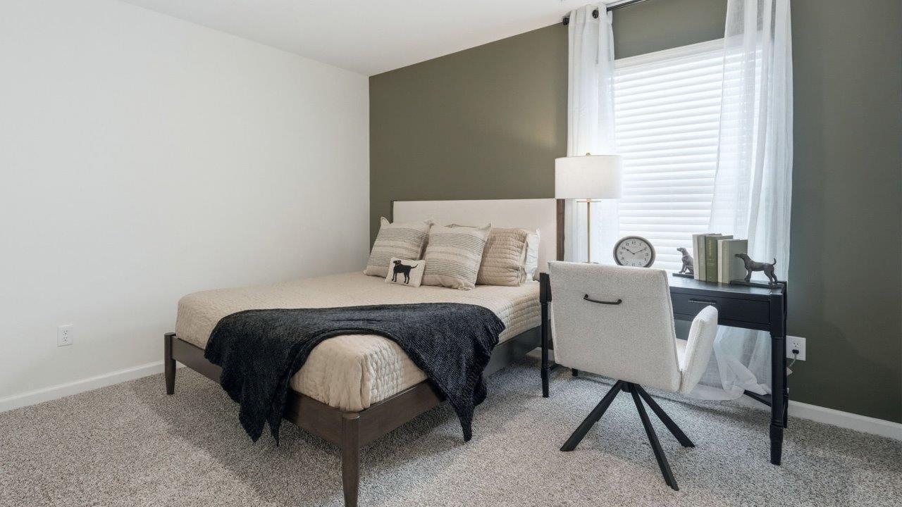 thunderhawk elm model home bedroom 2 with carpet flooring and white and green walls