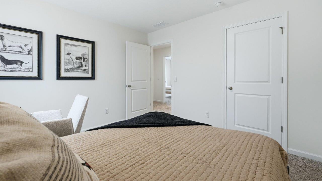 thunderhawk elm model home bedroom 2 with carpet flooring and white and green walls