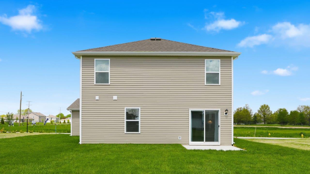 thunderhawk elm model home rear exterior with sod and concrete back patio
