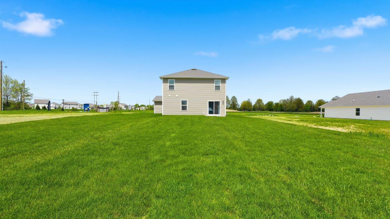 thunderhawk elm model home rear exterior with sod and concrete back patio