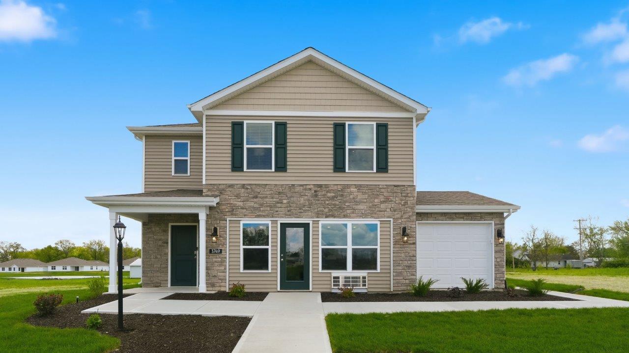 Thunderhawk elm model home exterior with ridgeline stone, sod, landscaping, and a 3 car garage