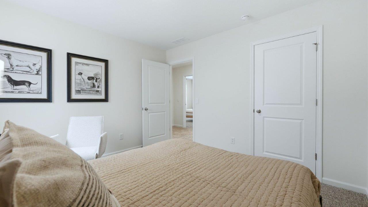 thunderhawk model home elm plan bedroom 2 with beige carpet, white and green walls, closet, and 1 window