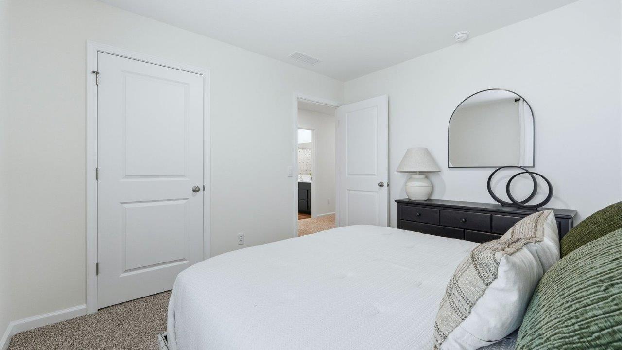 thunderhawk model home elm plan bedroom 3 with white walls, beige carpet, closet, and 1 window