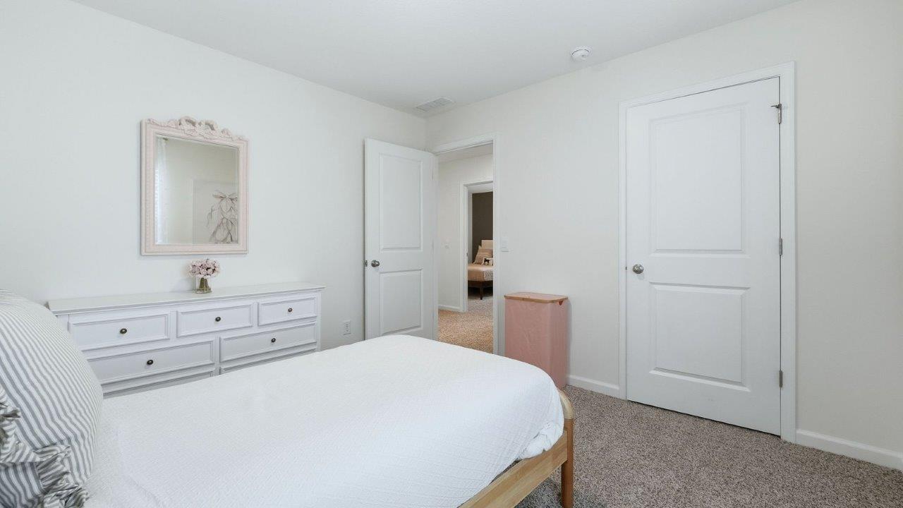 thunderhawk model home elm plan bedroom 4 with beige carpet, light pink walls, 1 window, and closet