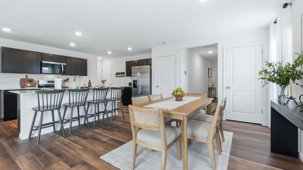 Thunderhawk elm model home open concept kitchen and dining room with mohawk lvp flooring