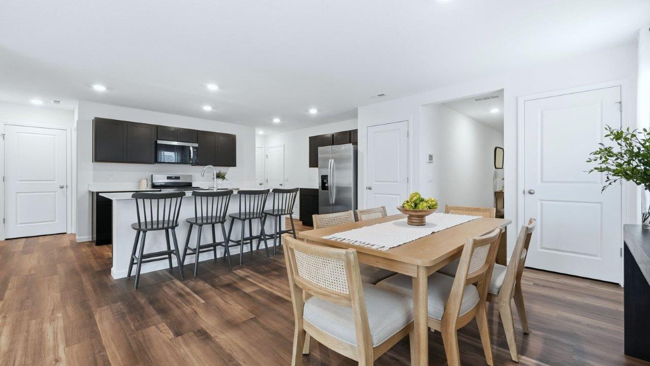 thunderhawk model home elm plan casual dining room with mohawk lvp flooring and plenty of natural lighting near kitchen and living room