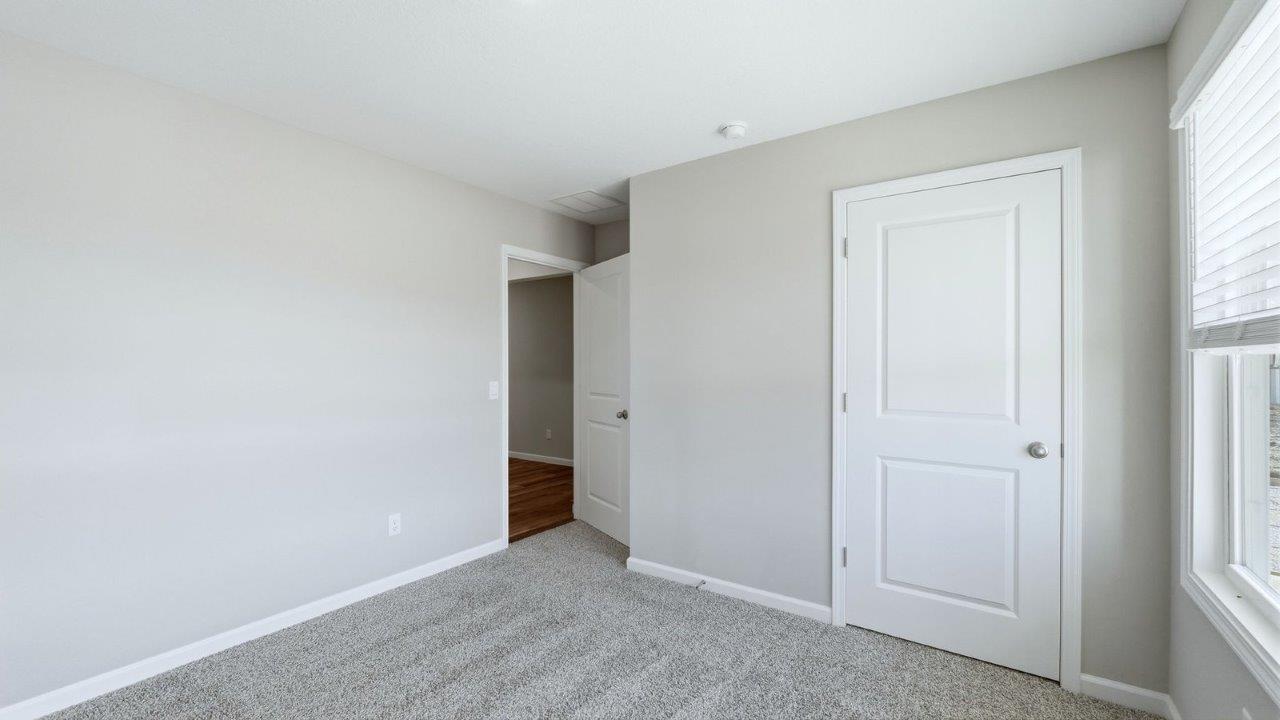 bedroom 2 with beige carpet, 2 windows, and popular grey walls