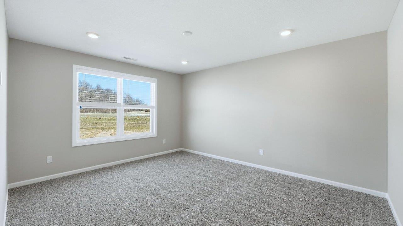 primary bedroom with beige carpet, popular grey walls, and ensuite bathroom and closet