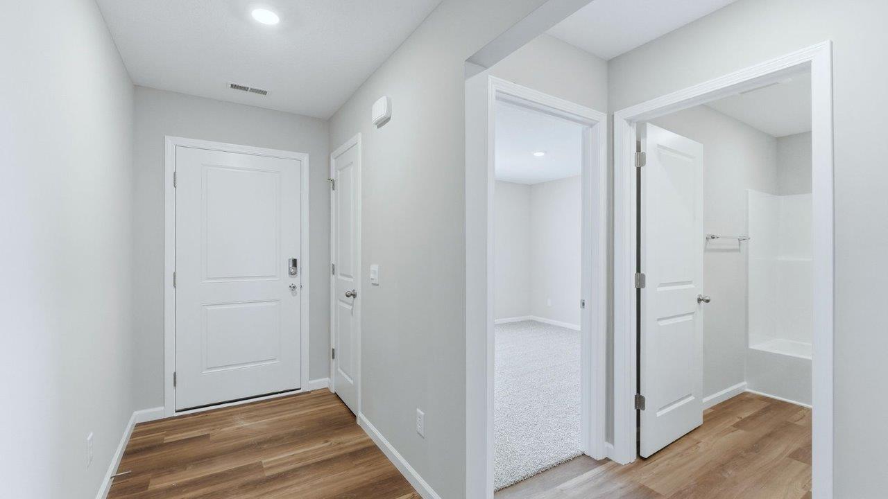 front door and foyer with lvp flooring and popular grey walls