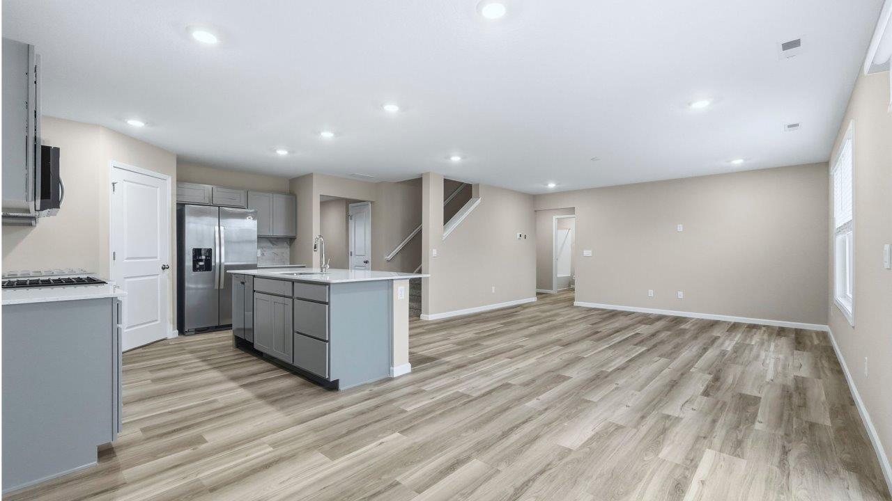 kitchen with grey cabinets, appliances, center island, and corner pantry