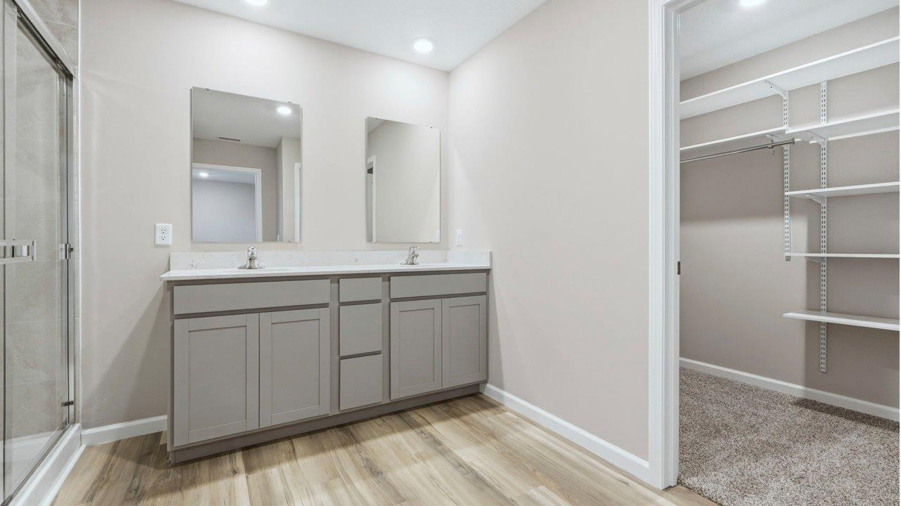 primary ensuite bath with dual sinks and walk in shower