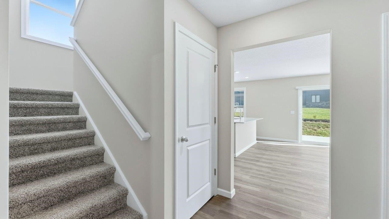 staircase and foyer leading to main living area