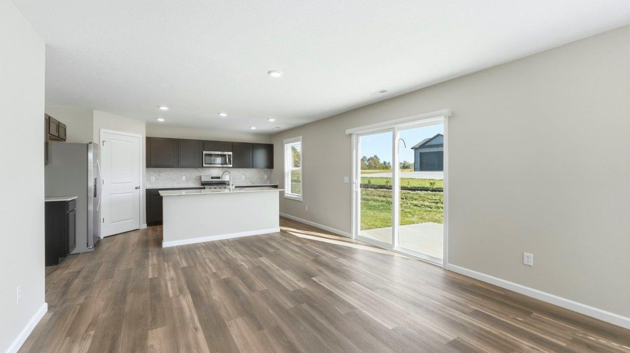 dining and living room with windows and sliding glass door to backyard patio