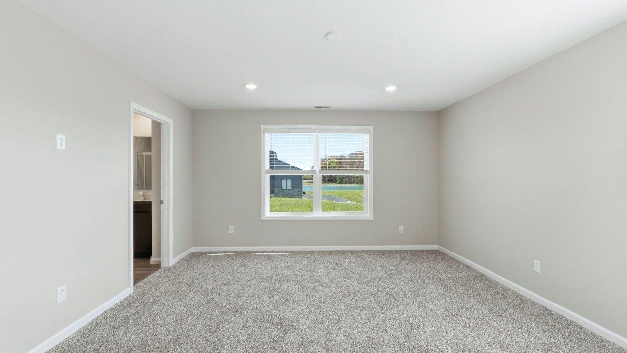 primary bedroom with carpet and ensuite bath and closet