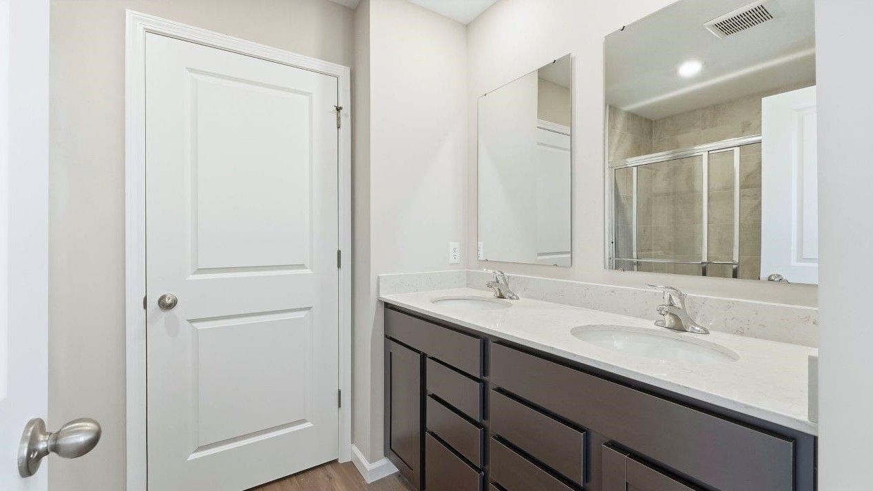 primary ensuite bathroom with dual sinks