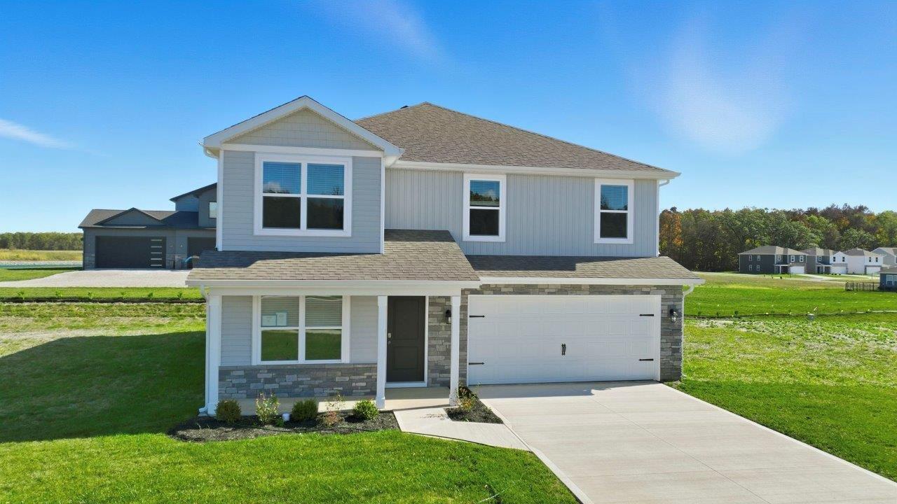 parlor bluffs stamford exterior with sodded yard, front porch, 2 car garage, and landscaped