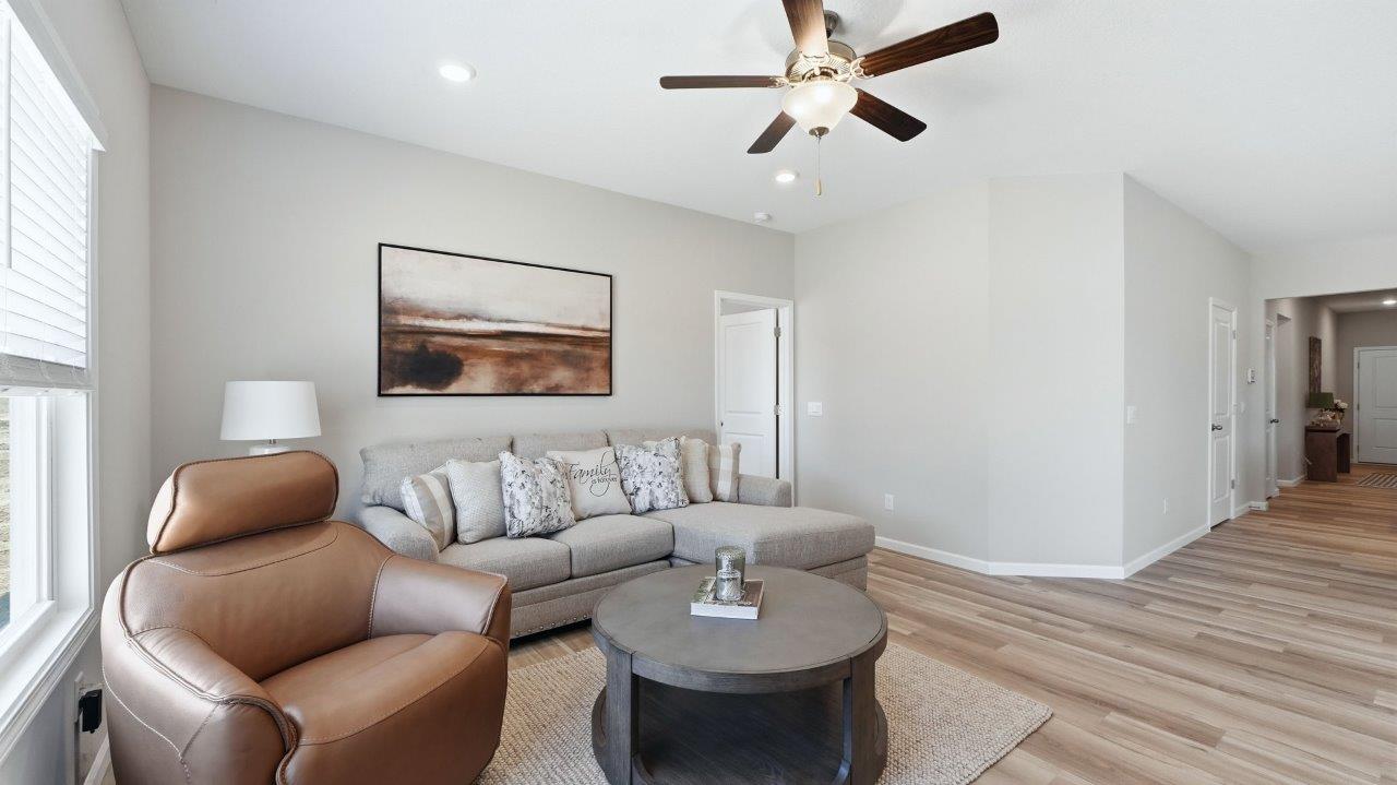 sierra ridge chatham model living room with lvp flooring, ceiling fan, and open layout