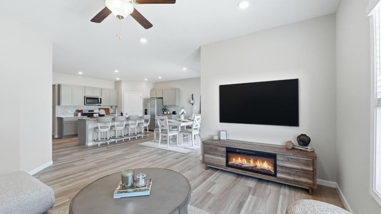 sierra ridge chatham model living room with lvp flooring, ceiling fan, and open layout