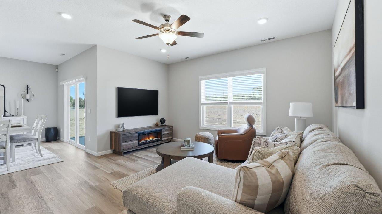 sierra ridge chatham model living room with lvp flooring, ceiling fan, and open layout