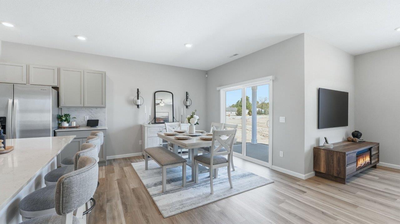 sierra ridge chatham dining room open layout with lvp flooring and sliding glass door to backyard patio